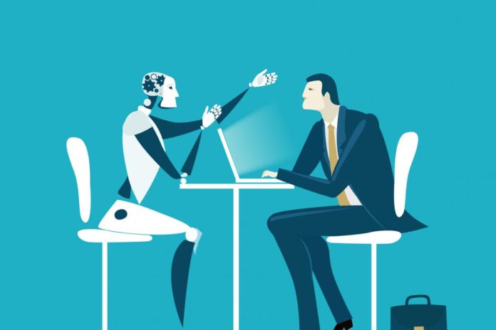 a robot sitting at a table with a laptop